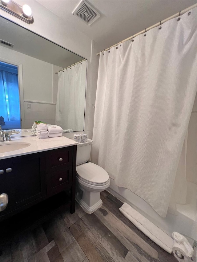 full bathroom featuring toilet, wood finished floors, visible vents, and vanity