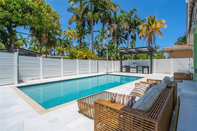 view of swimming pool featuring a fenced in pool, a fenced backyard, a patio area, and area for grilling