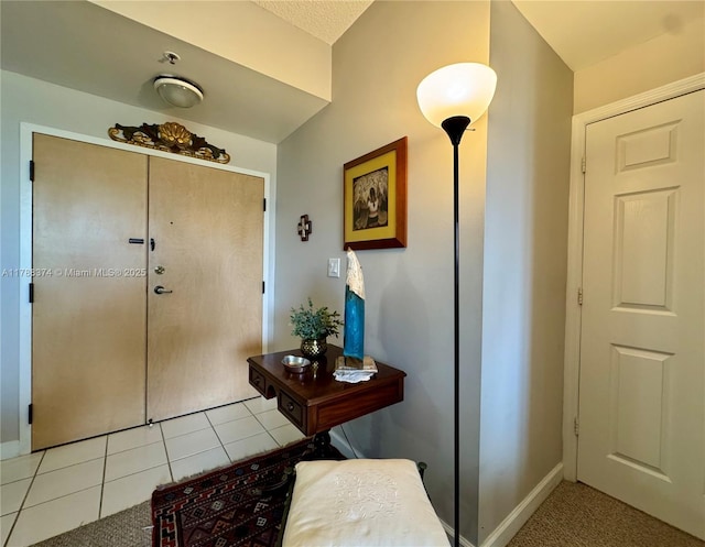 foyer featuring baseboards and light tile patterned floors