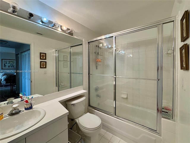 bathroom featuring vanity, tile patterned flooring, bath / shower combo with glass door, and toilet