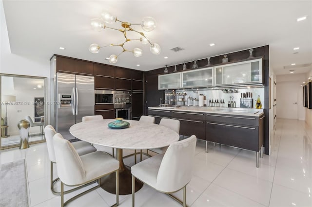 dining area featuring a chandelier, visible vents, and light tile patterned floors