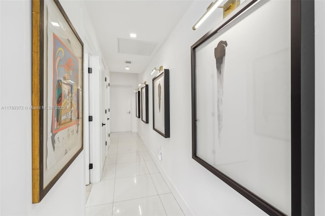 corridor featuring baseboards and light tile patterned floors