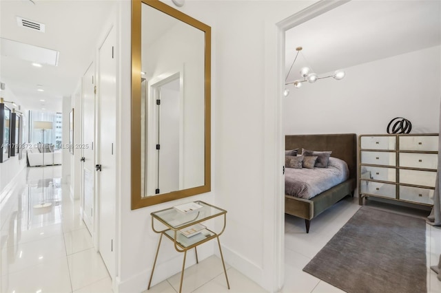 corridor featuring baseboards, tile patterned flooring, and visible vents