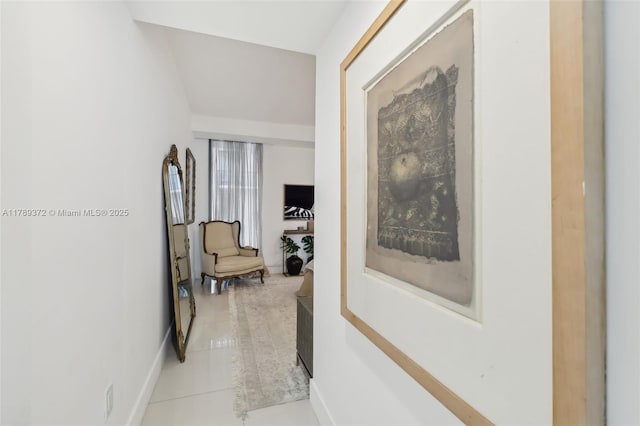 corridor with light tile patterned flooring and baseboards