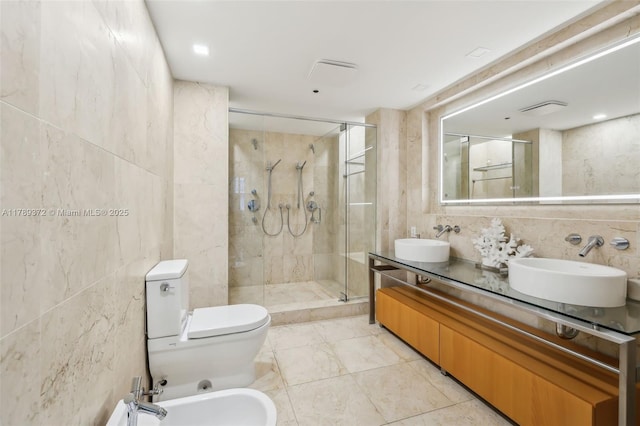 bathroom featuring a stall shower, a sink, and tile walls