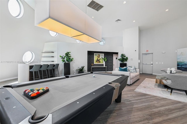 recreation room featuring visible vents, a towering ceiling, baseboards, wood finished floors, and pool table
