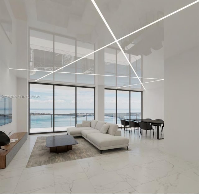 living area featuring a water view, marble finish floor, a towering ceiling, and a wall of windows