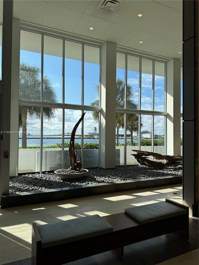 workout area with a water view, expansive windows, and visible vents