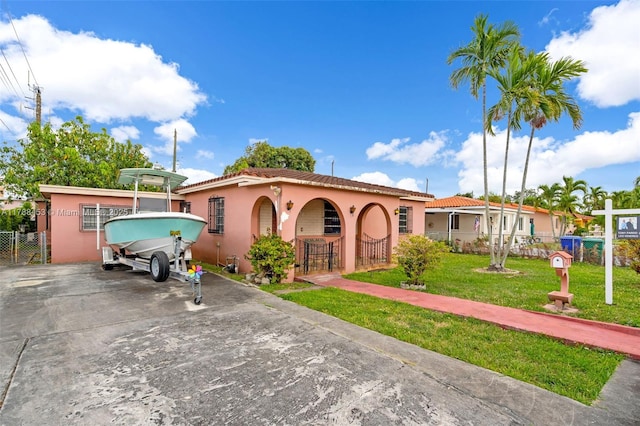 35 SW 60th Ave, Miami, FL 33144 - mediterranean / spanish-style house featuring stucco siding, a gate, fence, and a front yard