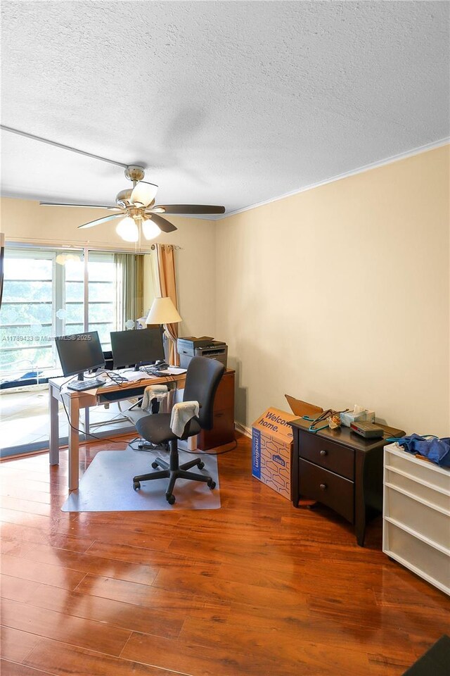 home office featuring wood finished floors, a textured ceiling, and a ceiling fan