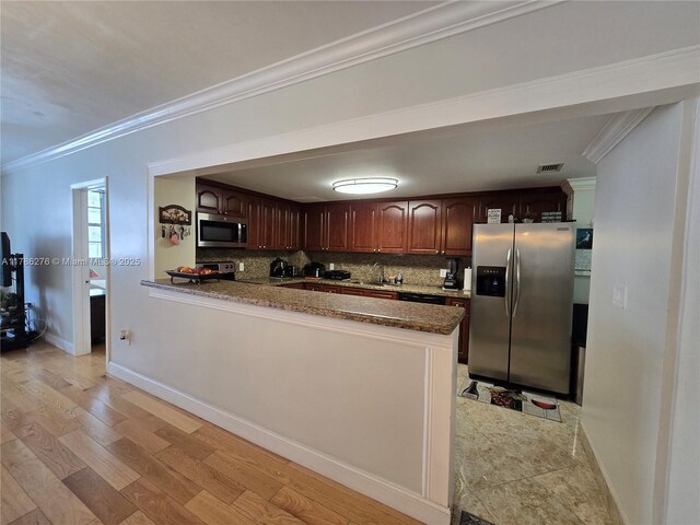 5825 Collins Ave Unit 2D, Miami Beach, FL 33140 - kitchen with a sink, appliances with stainless steel finishes, ornamental molding, a peninsula, and backsplash