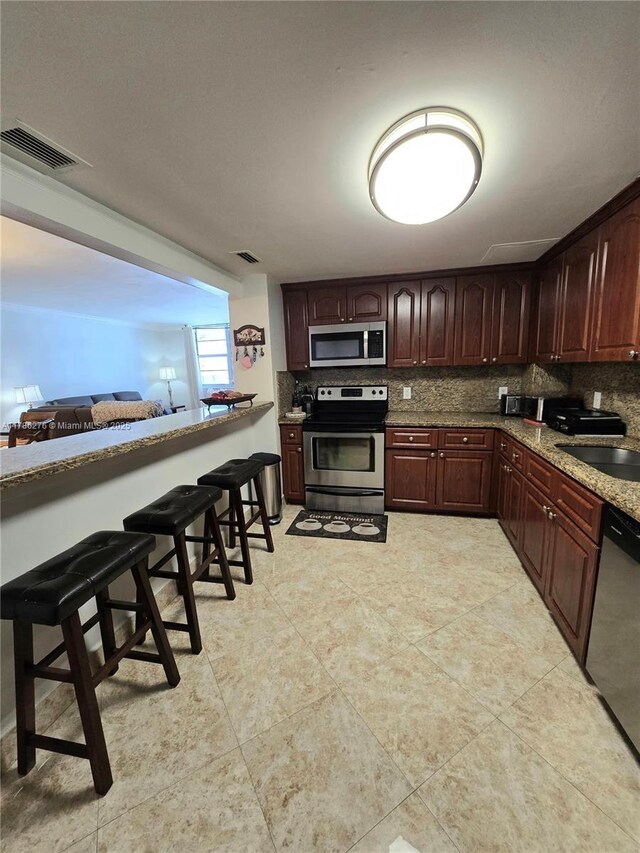 5825 Collins Ave Unit 2D, Miami Beach, FL 33140 - kitchen with backsplash, visible vents, appliances with stainless steel finishes, and a sink