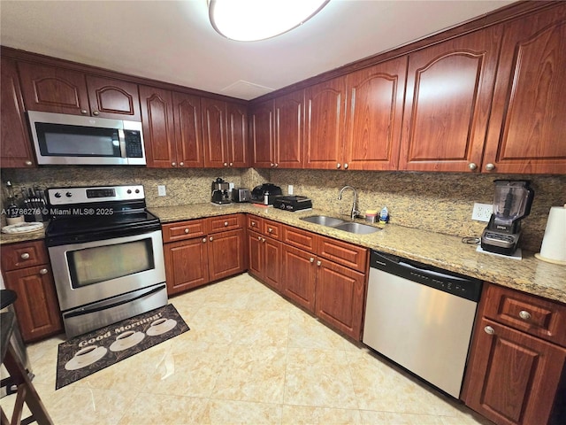 5825 Collins Ave Unit 2D, Miami Beach, FL 33140 - kitchen featuring tasteful backsplash, stainless steel appliances, light stone counters, and a sink