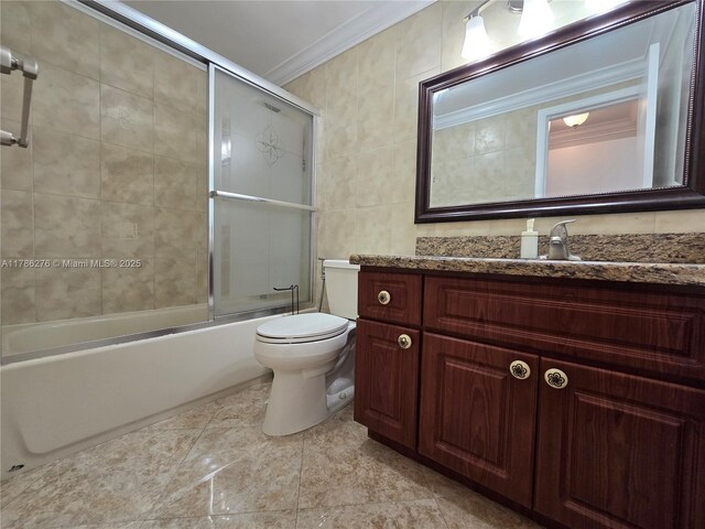 5825 Collins Ave Unit 2D, Miami Beach, FL 33140 - bathroom featuring tile walls, shower / bath combination with glass door, toilet, vanity, and crown molding