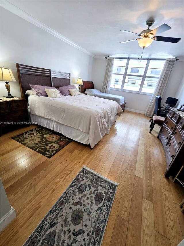5825 Collins Ave Unit 2D, Miami Beach, FL 33140 - bedroom with ceiling fan, baseboards, crown molding, and light wood-style floors