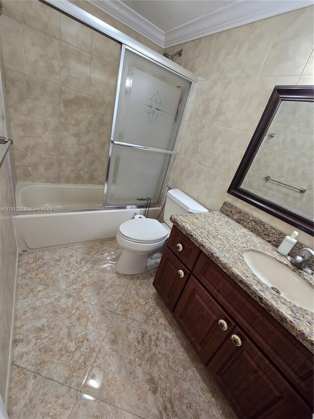 5825 Collins Ave Unit 2D, Miami Beach, FL 33140 - full bath with enclosed tub / shower combo, tile walls, toilet, vanity, and crown molding