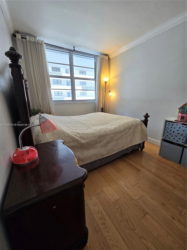 5825 Collins Ave Unit 2D, Miami Beach, FL 33140 - bedroom featuring baseboards, wood finished floors, and crown molding