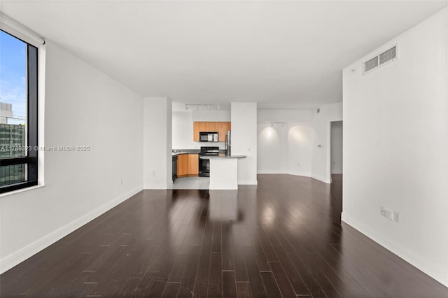 1330 W Ave Unit 1614, Miami Beach, FL 33139 - unfurnished living room featuring track lighting, baseboards, dark wood-style flooring, and visible vents