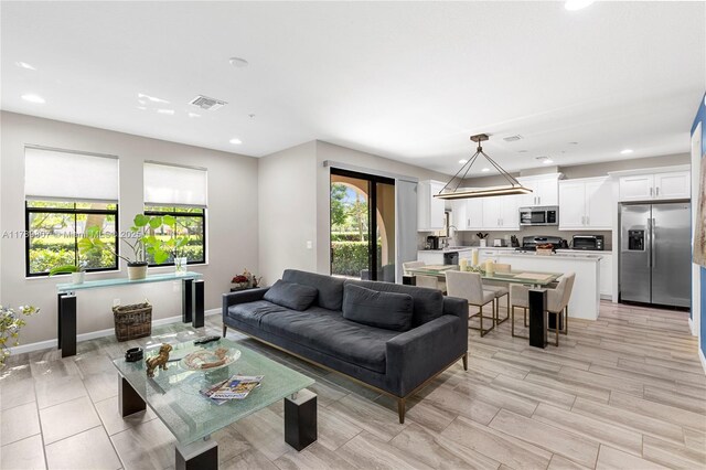 living room featuring visible vents, recessed lighting, and a healthy amount of sunlight