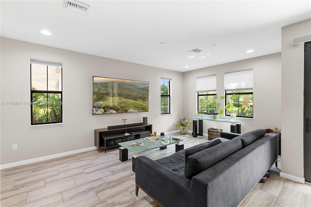 living area featuring baseboards, visible vents, and recessed lighting