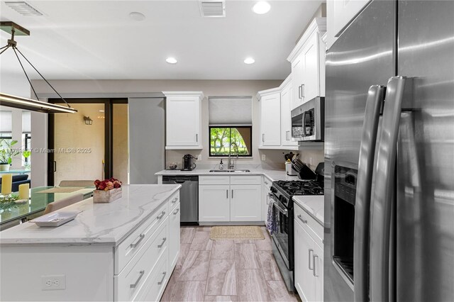 kitchen featuring white cabinets, visible vents, stainless steel appliances, and a sink