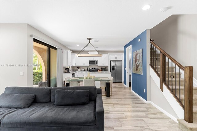living area with stairway, baseboards, and recessed lighting