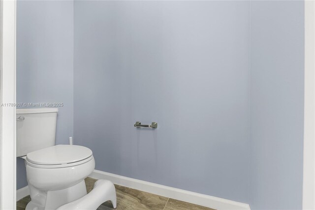 bathroom featuring toilet and baseboards