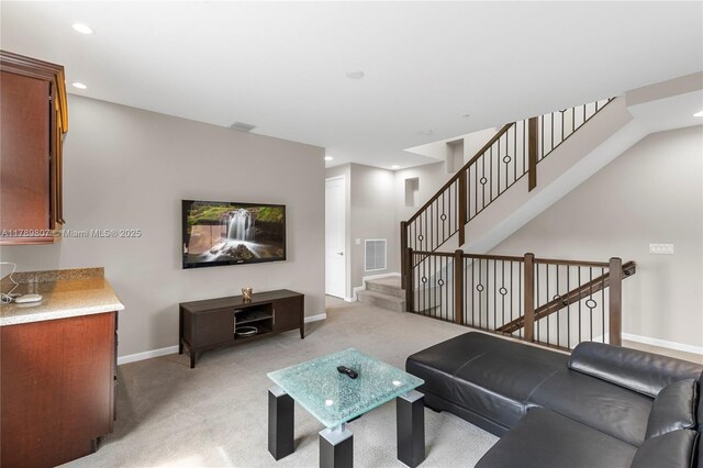 living room featuring recessed lighting, stairway, visible vents, light carpet, and baseboards