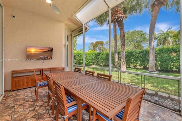 sunroom / solarium featuring outdoor dining space and a ceiling fan