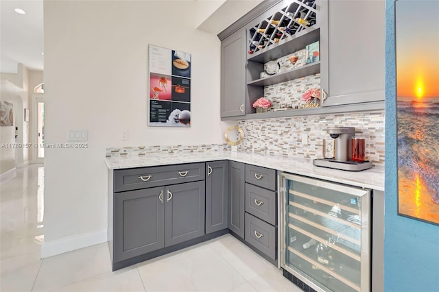 bar with backsplash, baseboards, light tile patterned flooring, indoor bar, and wine cooler