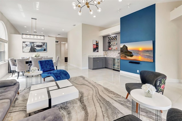 living area with wine cooler, baseboards, recessed lighting, a notable chandelier, and a bar