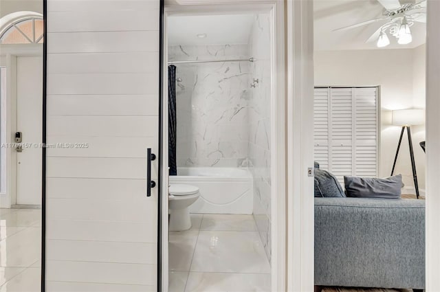 ensuite bathroom with bathing tub / shower combination, a ceiling fan, toilet, and ensuite bathroom