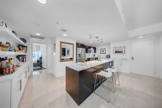 665 NE 25th St Unit 1201, Miami, FL 33137 - kitchen with a sink, stainless steel fridge with ice dispenser, light countertops, white cabinetry, and visible vents