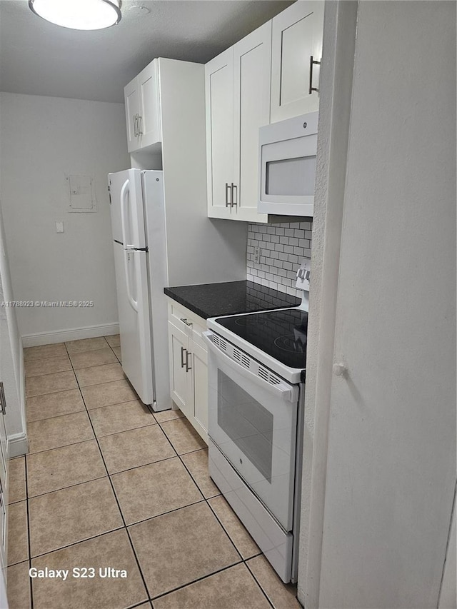 kitchen featuring tasteful backsplash, light tile patterned flooring, dark countertops, white cabinetry, and white appliances