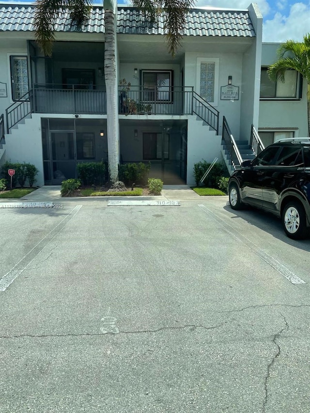 view of building exterior featuring uncovered parking and stairs