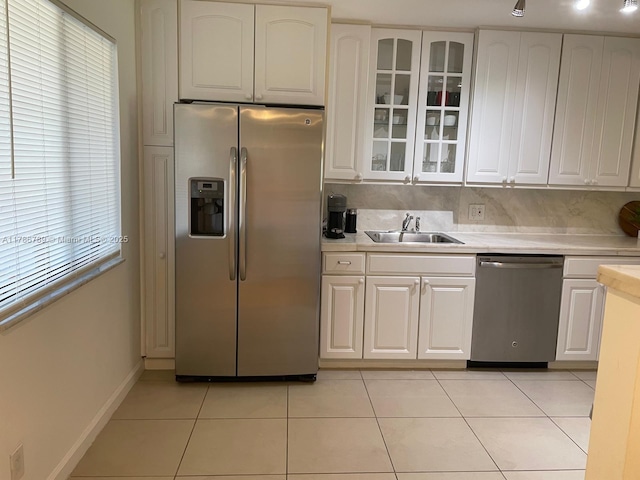 kitchen featuring stainless steel appliances, light countertops, a sink, and light tile patterned flooring