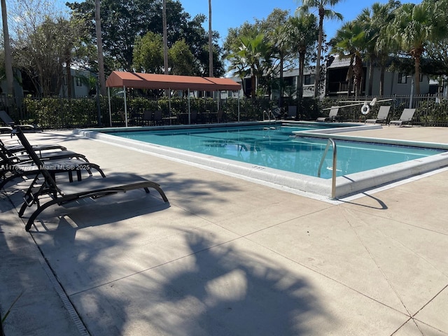 community pool featuring fence and a patio