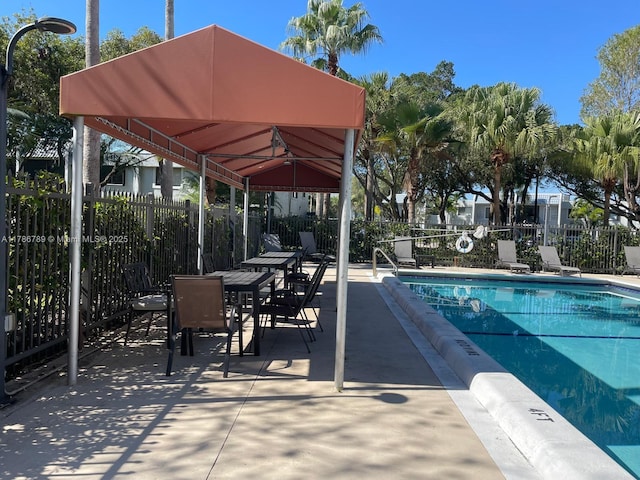 community pool featuring a gazebo, a patio area, and fence