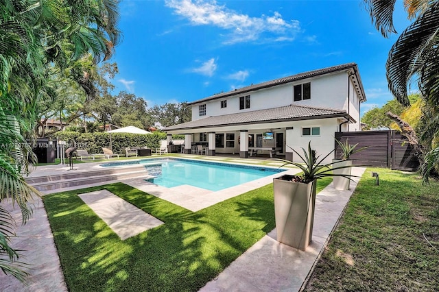 view of pool with a fenced backyard, a jacuzzi, and a yard
