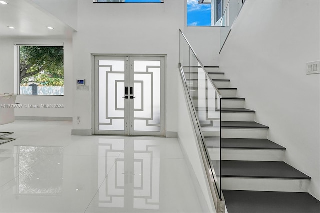 entryway featuring baseboards, recessed lighting, stairs, and a towering ceiling