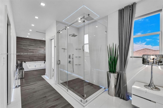 full bathroom featuring a whirlpool tub, recessed lighting, a shower stall, and wood finished floors