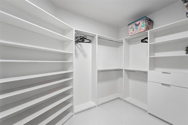 spacious closet with light tile patterned floors