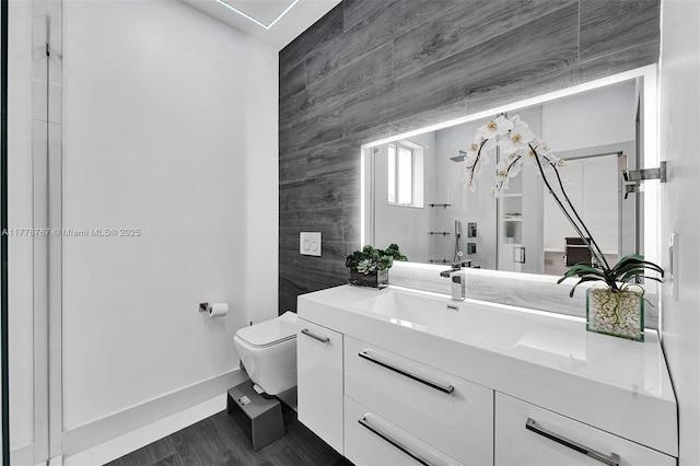 bathroom with vanity, baseboards, and toilet