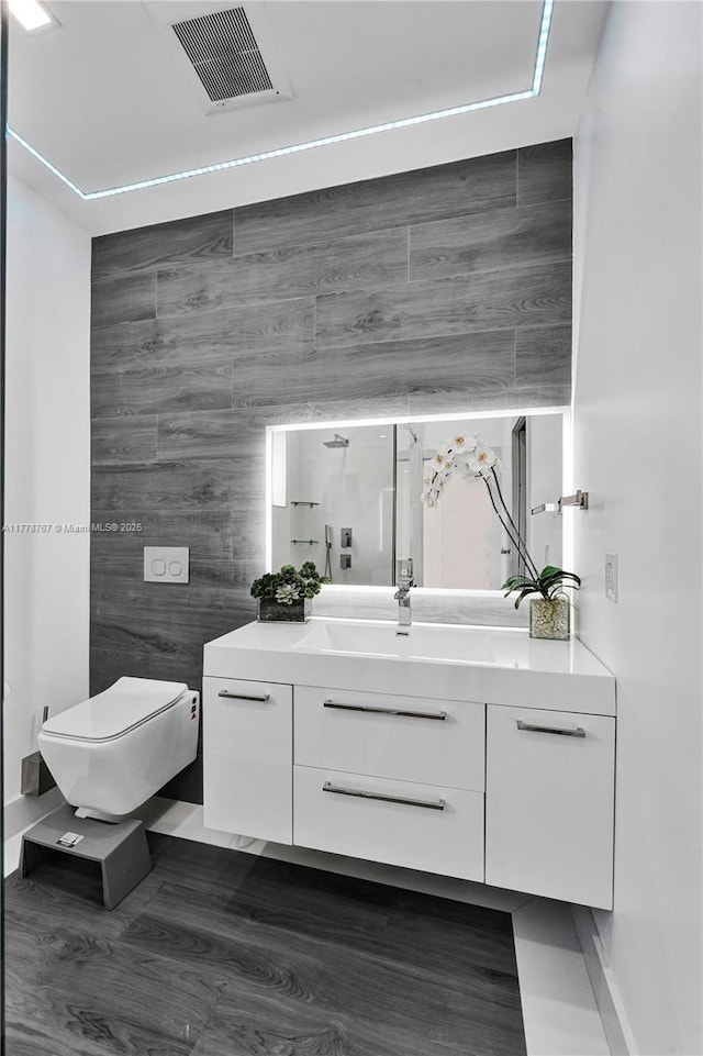 bathroom with toilet, visible vents, a shower, and vanity