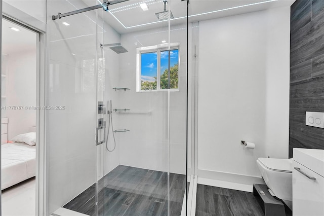 ensuite bathroom featuring a shower stall, toilet, ensuite bath, and wood finished floors
