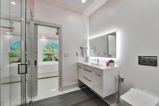 full bathroom featuring vanity, wood finished floors, toilet, ensuite bathroom, and baseboards