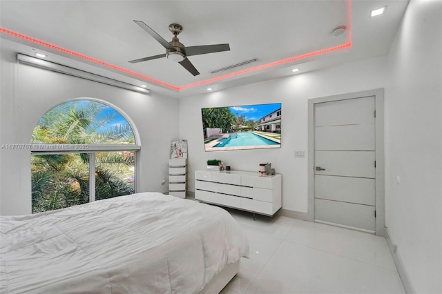 bedroom with ceiling fan, visible vents, light tile patterned floors, a tray ceiling, and recessed lighting