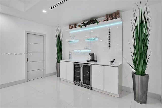 bar with indoor wet bar, light tile patterned flooring, and beverage cooler