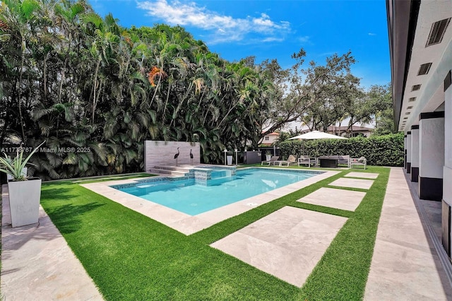 view of swimming pool with a lawn, a fenced backyard, a pool with connected hot tub, and a patio area