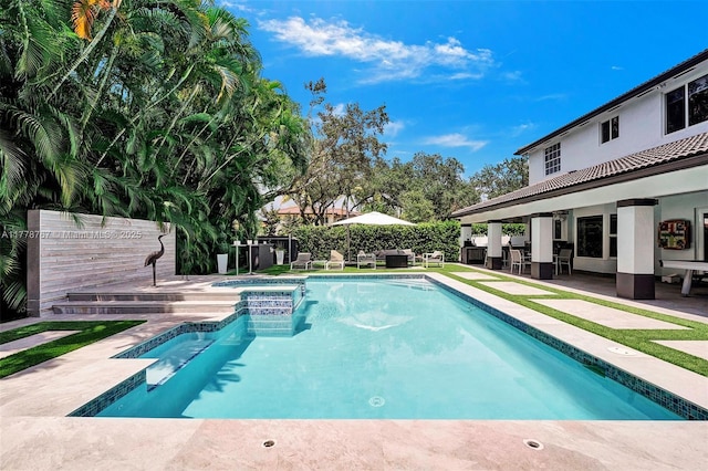 view of swimming pool featuring a fenced backyard, a patio, and a pool with connected hot tub